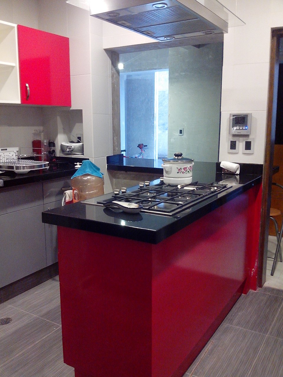 Cocina integral con isla roja y cubierta negra