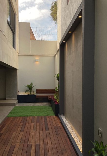 Patio interior con deck de madera y banca
